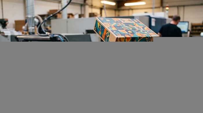 Colorful custom-printed cardboard boxes on a digital packaging press ready for short-run production