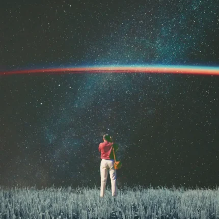 Person in a red shirt standing in a field under a starry galactic sky