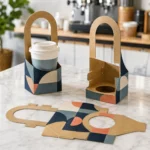 Kraft single-cup holders with arched handles and geometric print, one holding a cup